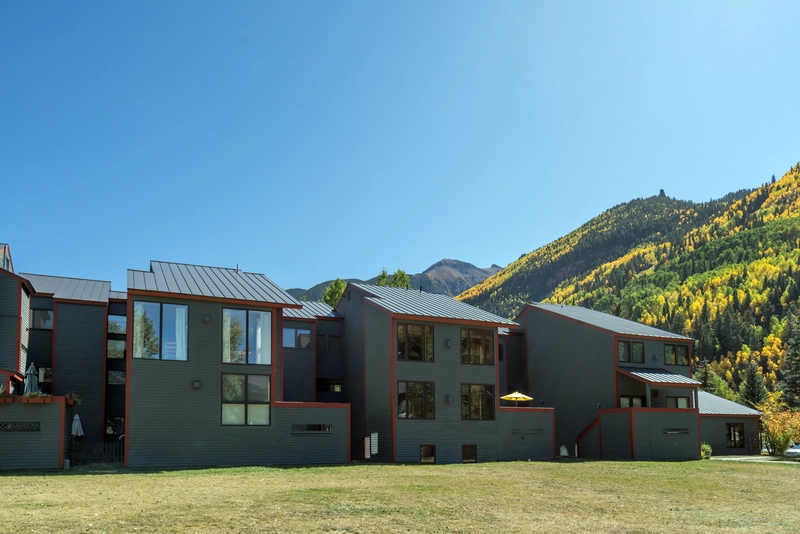3 story condominium with gray walls and a green mountain background making it the best telluride airbnb