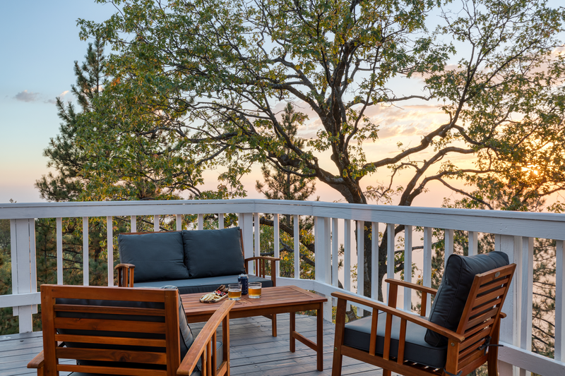 blue wooden sofa outside the deck balcony during sunset making it the best lake arrowhead airbnb