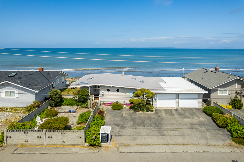 white 1 level house fronting turquoise ocean waves making it the best whidbey island airbnb